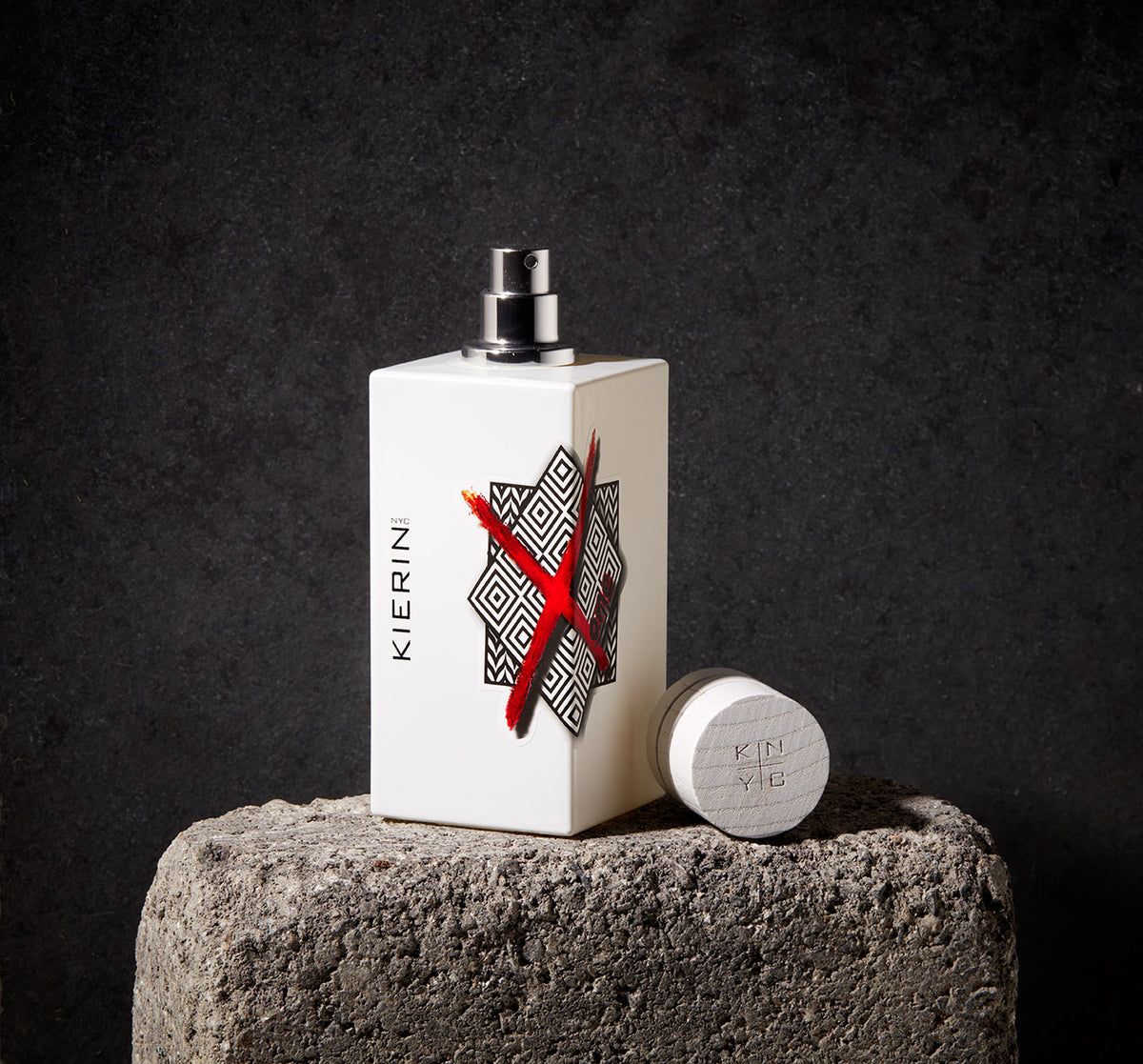 KIERIN ScentXone perfume bottle with exposed atomizer and cap on a stone pedestal.