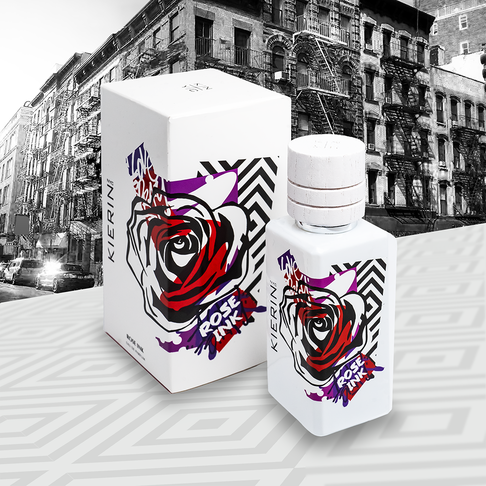 Perfume bottle and box, each with a bold red, black, and purple rose design. Background shows a black-and-white urban street with old buildings.