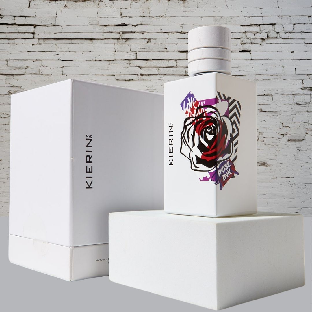 KIERIN Rose Ink 100 ml perfume and white box against a white brick wall.