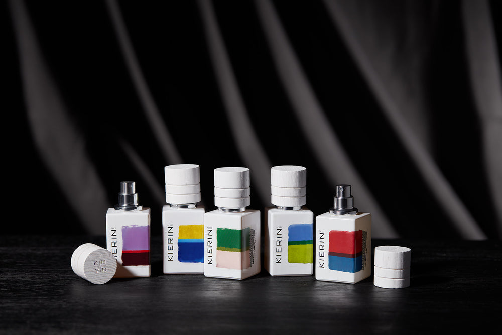 Colorful KIERIN Abstract Art perfume bottles against a black background.