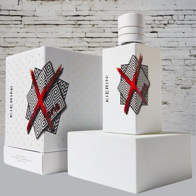 KIERIN ScentXone 100 ml perfume and white box against a white brick wall.