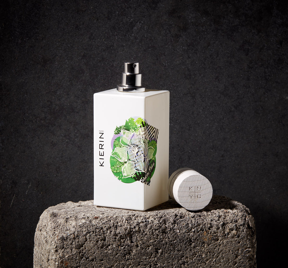 KIERIN Santal Park perfume bottle with green floral artwork and cap on a stone pedestal.