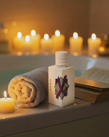 KIERIN ScentXme perfume beside a rolled towel and candles by a bathtub.
