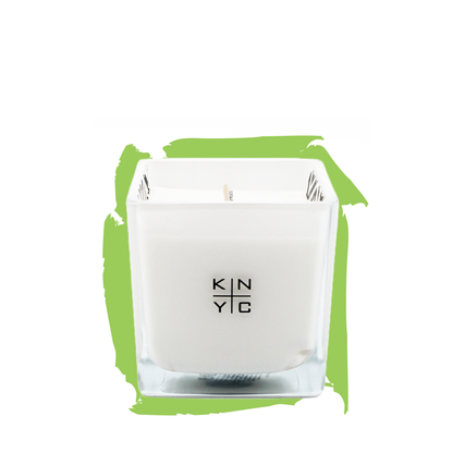 KIERIN 10 A.M. Flirt candle in a square glass vessel against a green brushstroke.