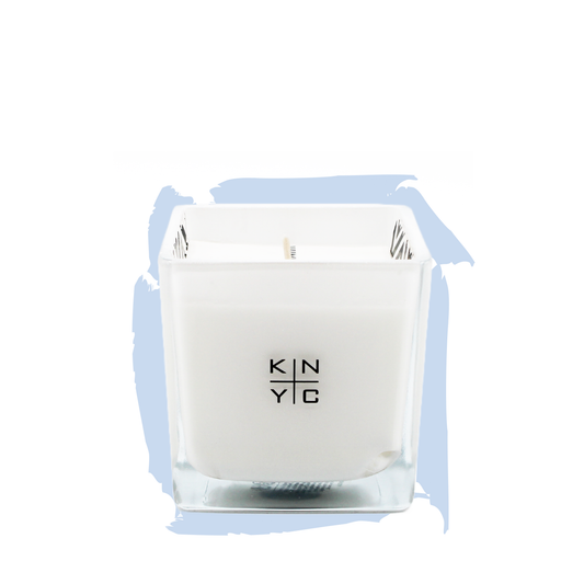KIERIN Santal Sky candle in a square glass vessel against a pale blue brushstroke.