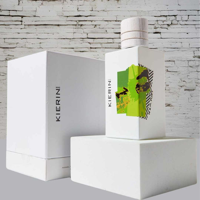 KIERIN 10 A.M. Flirt 100 ml perfume and white box against a white brick wall.